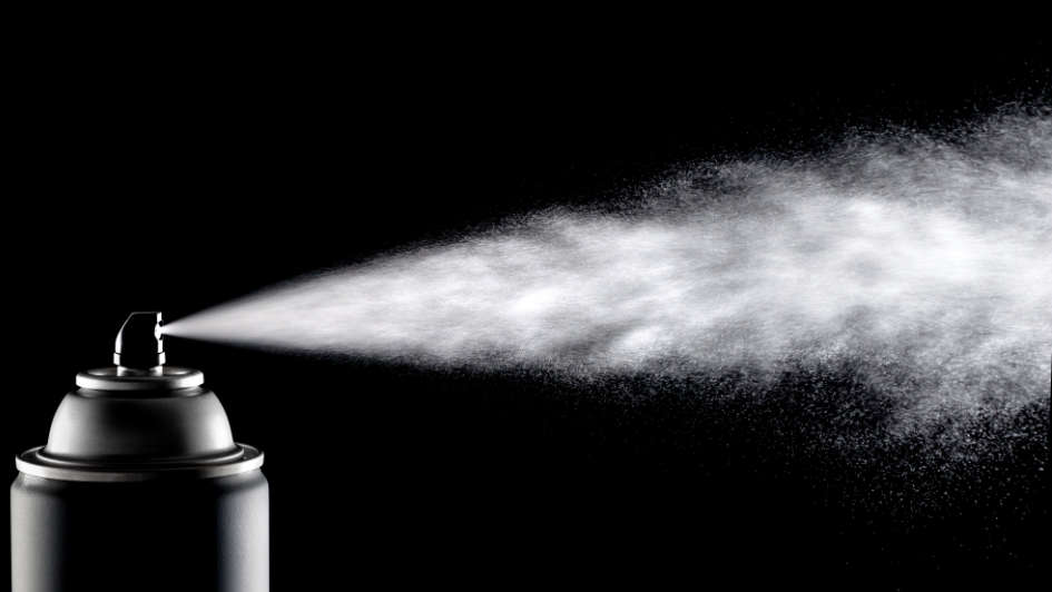 Spraydose versprüht Aerosol vor schwarzem Hintergrund